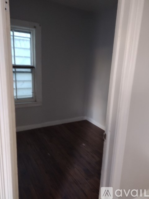 A room with a window and wooden floors.