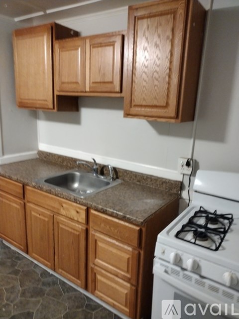 A kitchen with a white stove and wooden cabinets.