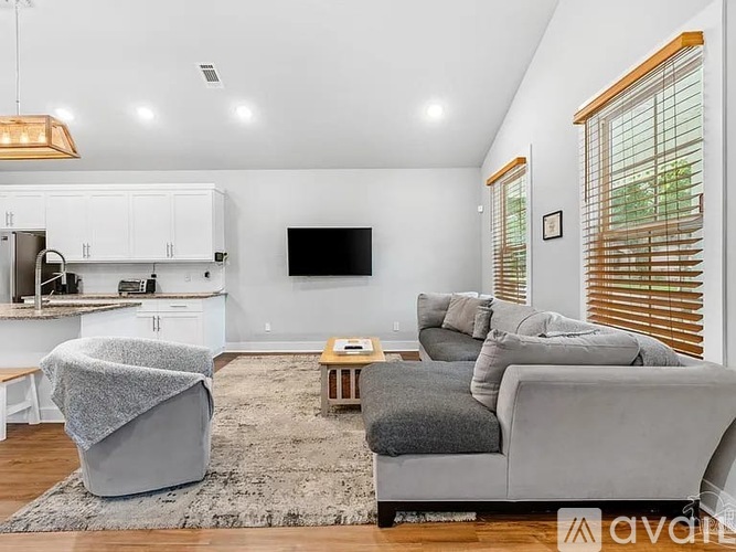A modern living room with a grey sofa and a television.