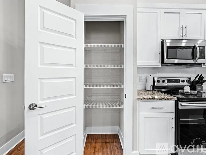 A kitchen with white cabinets and appliances.