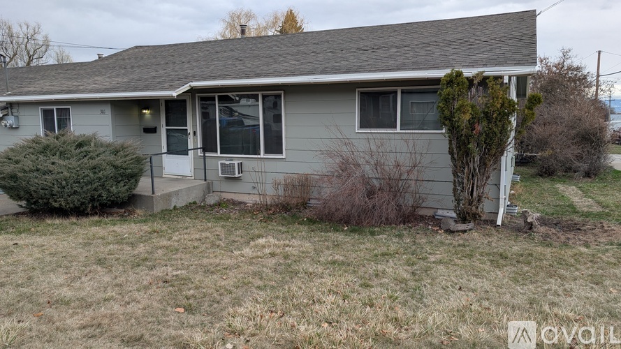 A house with a gray roof and a small front yard.