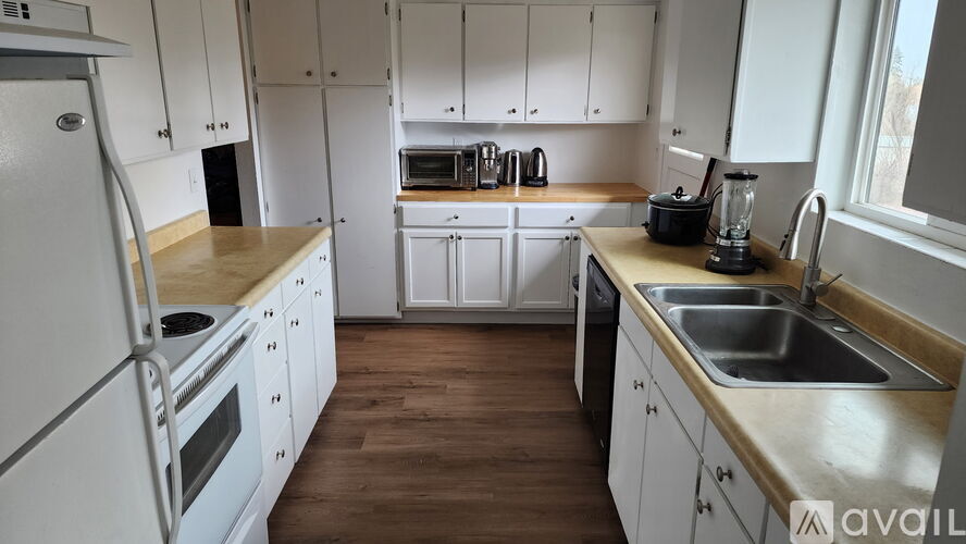 A kitchen with white cabinets and a wooden countertop.