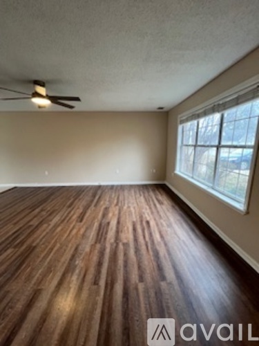 A room with wooden flooring and a window.