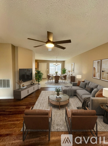 A living room with a brown sofa, a coffee table, and a television.
