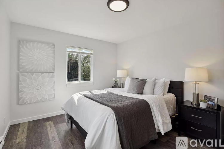 A bedroom with a large bed and a window with a white frame.