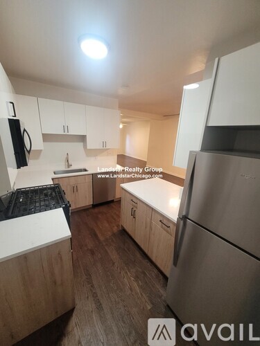 A kitchen with wooden cabinets and a stainless steel refrigerator.
