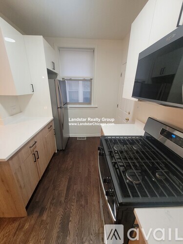 A kitchen with a stove top oven and a refrigerator.