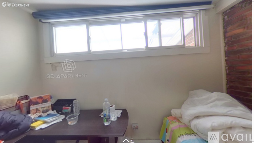 A small room with a bed, a table, and a window.