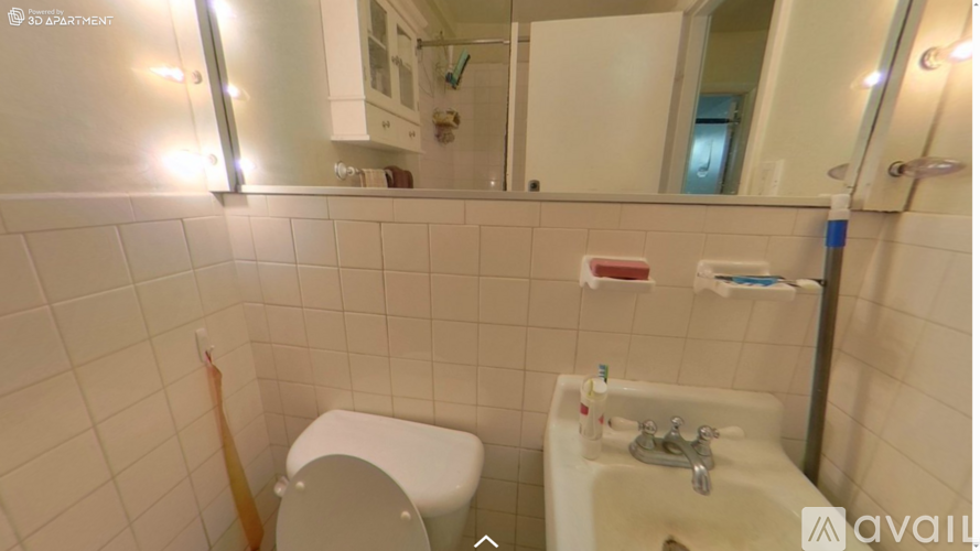 A bathroom with a toilet, sink, and mirror.