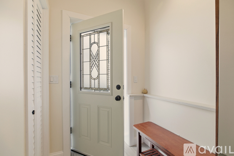 A white door with a glass window and a wooden bench in front of it.