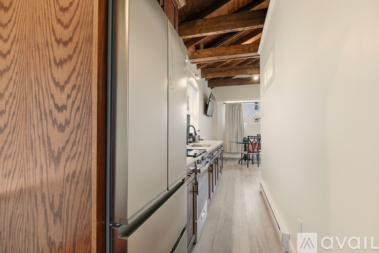 A kitchen with wooden cabinets and a stainless steel refrigerator.