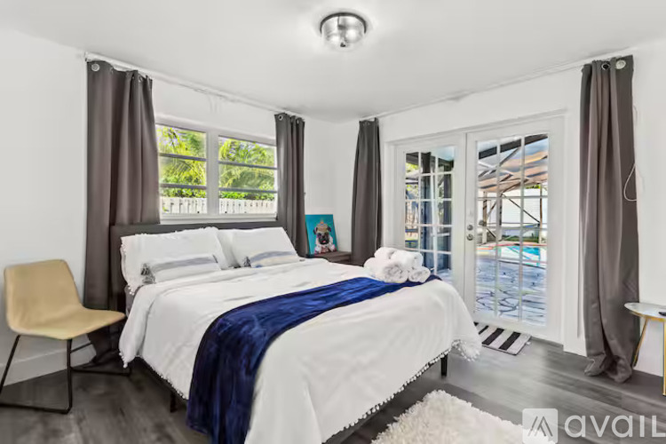 A bedroom with a large bed and a chair.