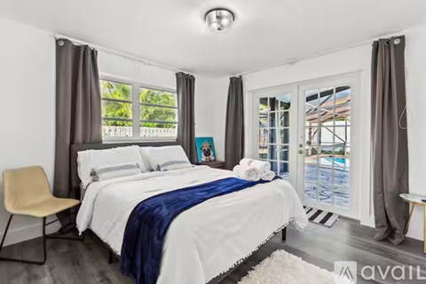 A bedroom with a large bed and a chair.