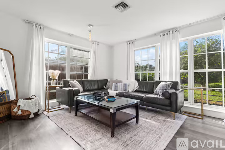 A modern living room with a glass coffee table and a large window.