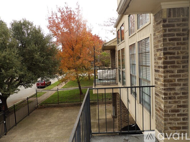A balcony with a black railing and a brick wall.
