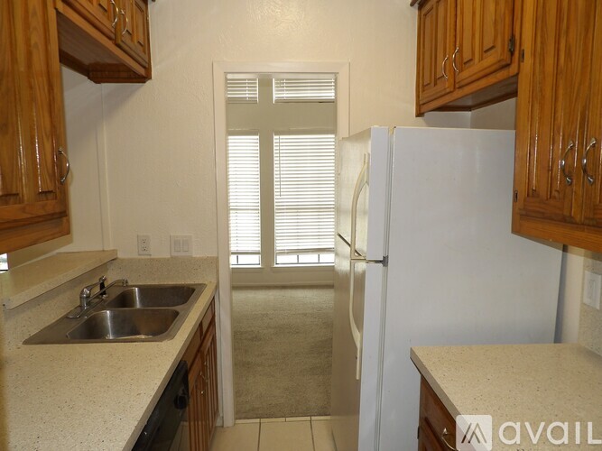 A kitchen with wooden cabinets and a white refrigerator.