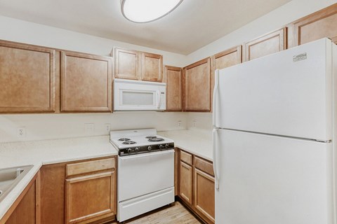 A kitchen with wooden cabinets and white appliances.
