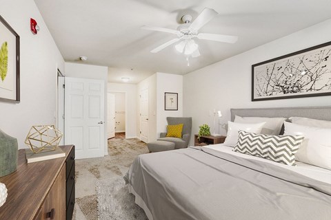 A bedroom with a large bed and a ceiling fan.