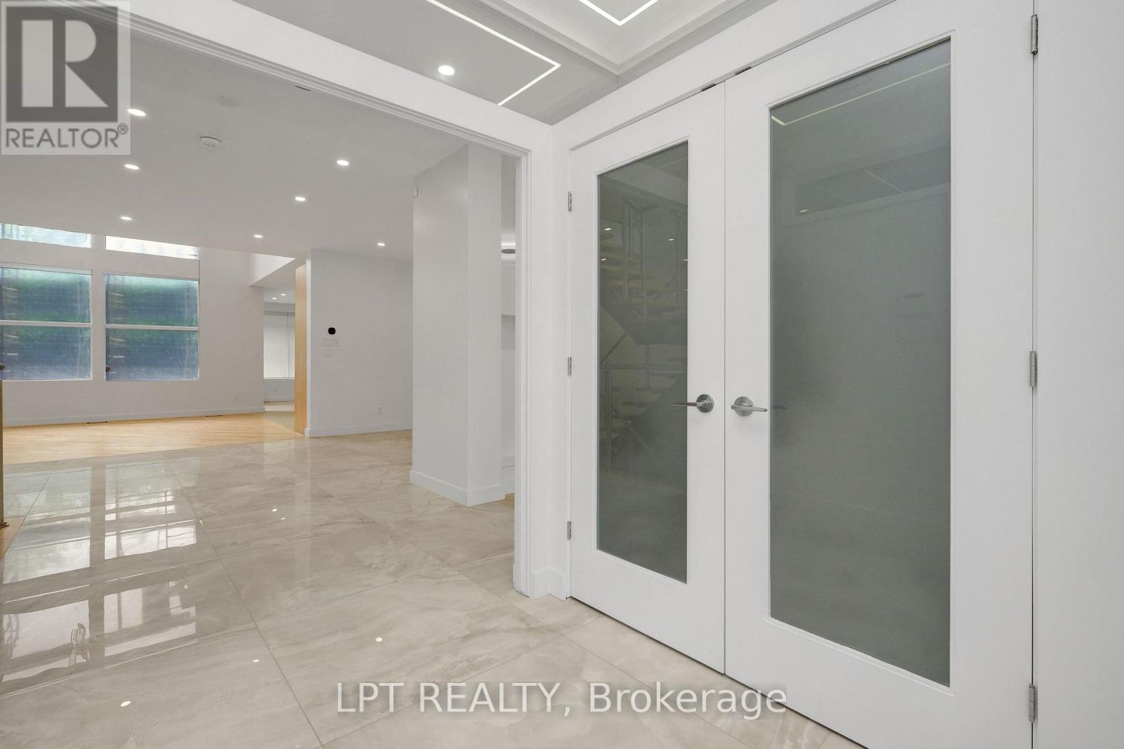 A spacious room with a glass door leading to another room.