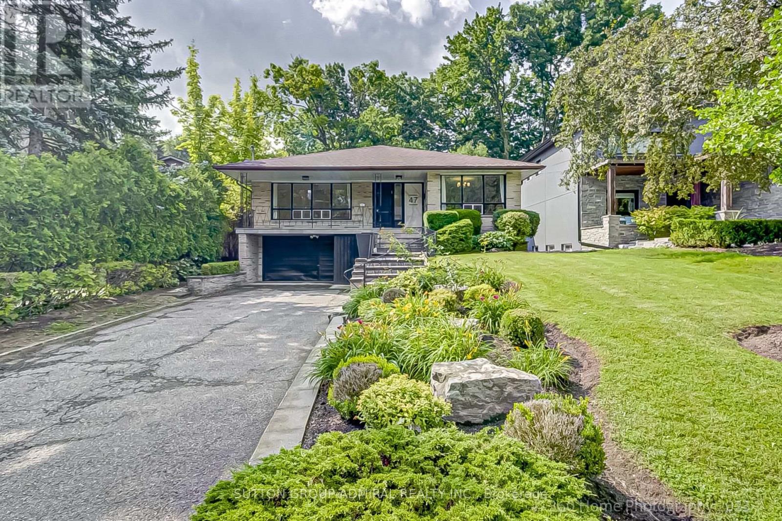 A house with a driveway and landscaping in front.