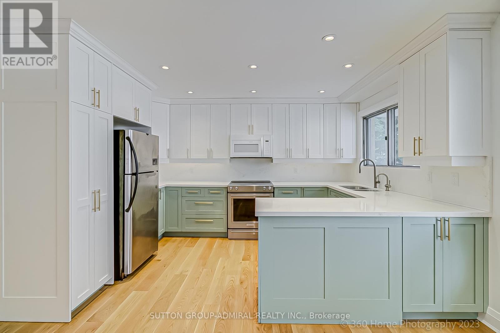 A kitchen with white cabinets and a wooden floor.
