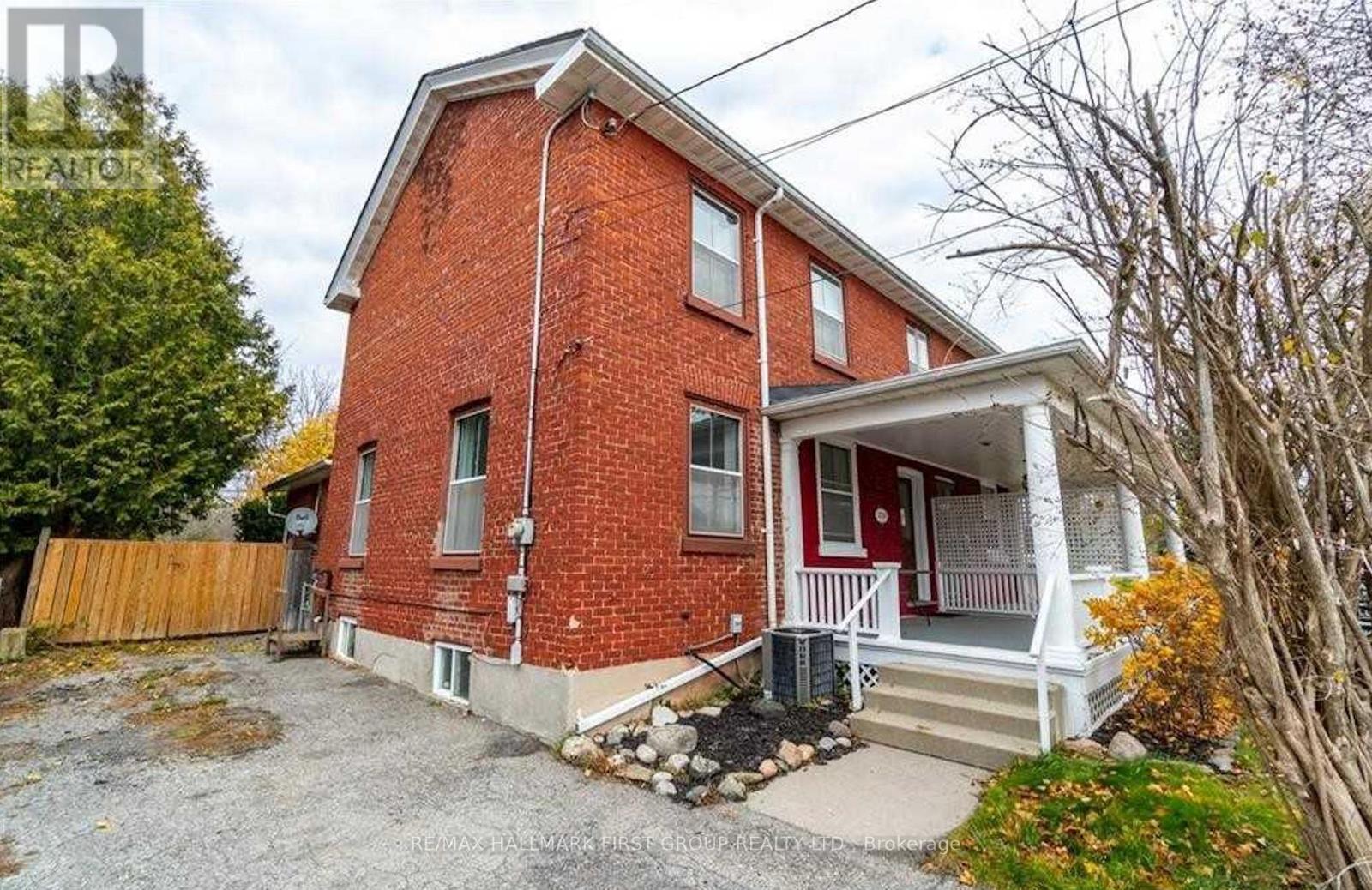 A red brick house with a white porch.