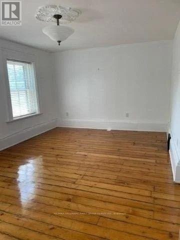 A room with wooden flooring and a chandelier.