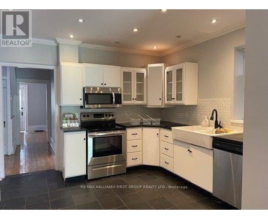 A kitchen with white cabinets and black countertops.