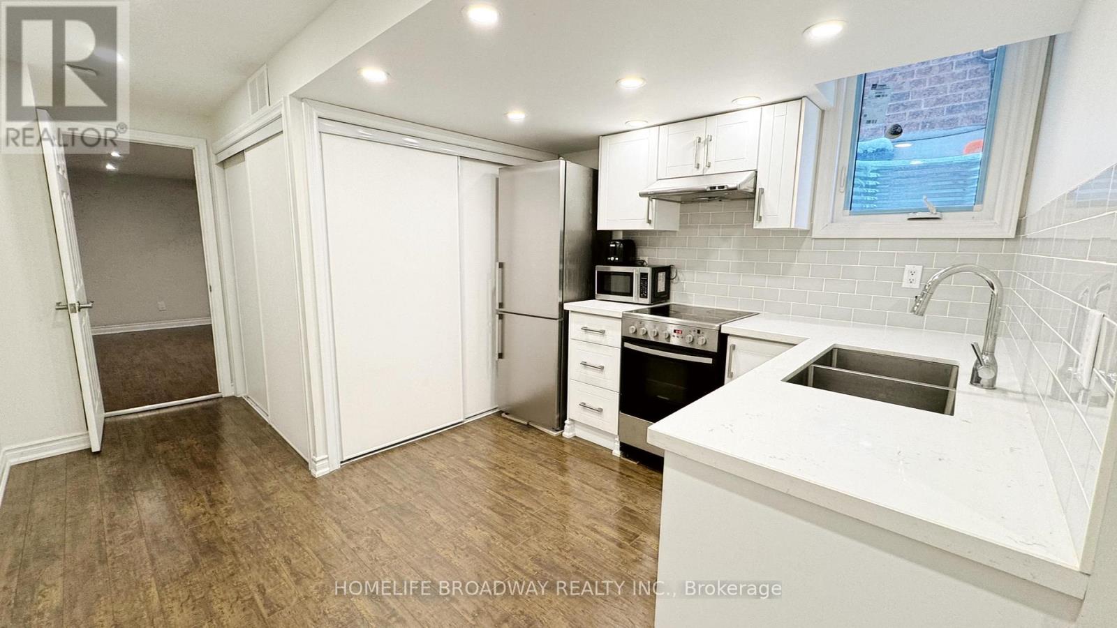 A kitchen with white cabinets and a white counter top.