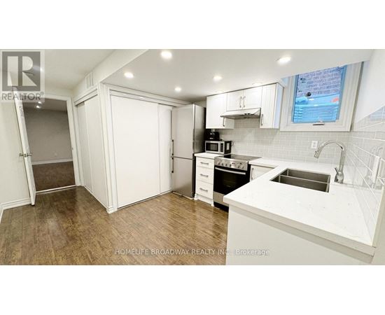 A kitchen with white cabinets and a white counter top.