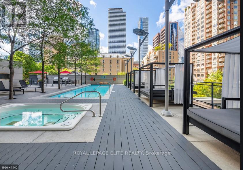 A pool area with a bench and a pool with water.