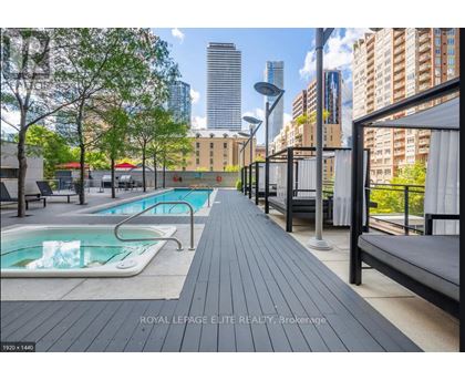 A pool area with a bench and a pool with water.