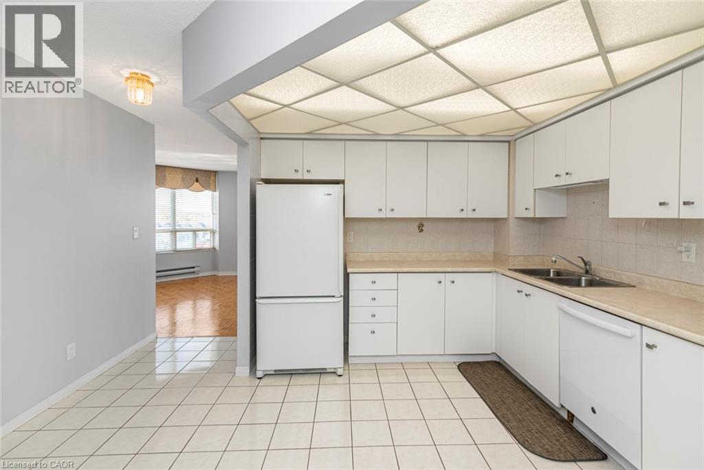 A kitchen with white cabinets and a white fridge.