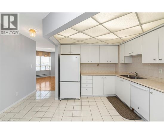 A kitchen with white cabinets and a white fridge.