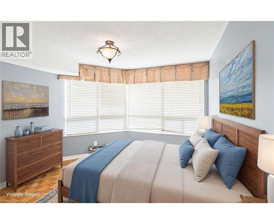 A bedroom with a bed, nightstand, and window with blinds.