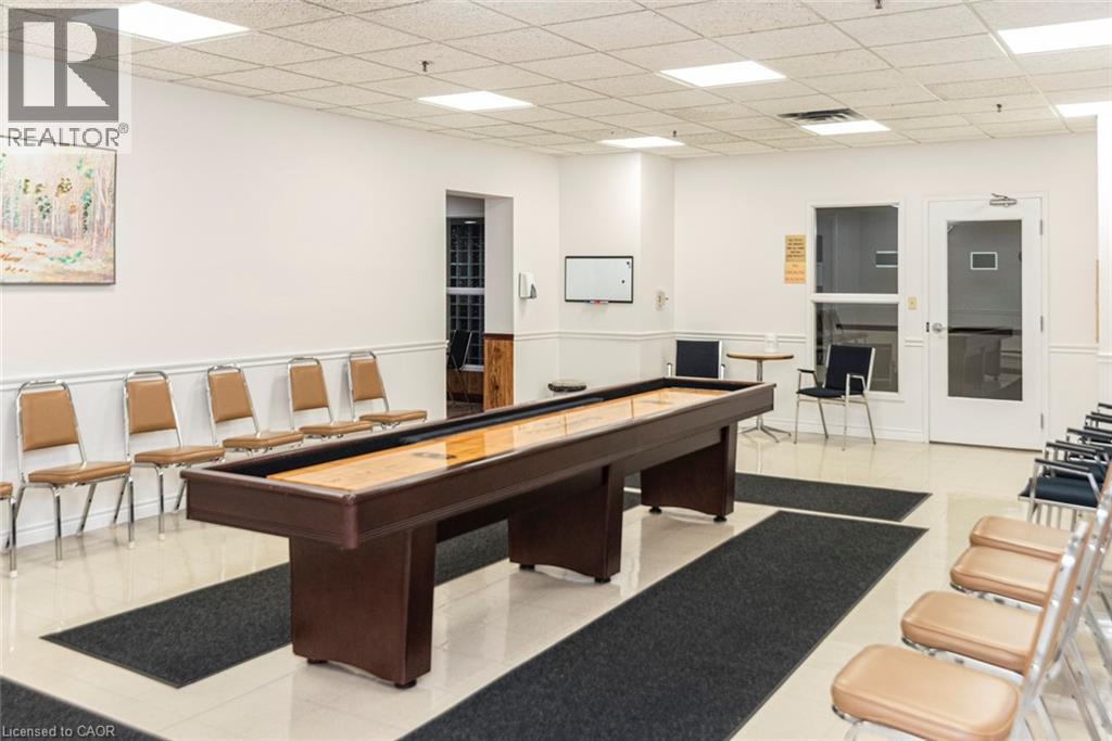 A room with a pool table and chairs.
