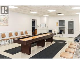 A room with a pool table and chairs.