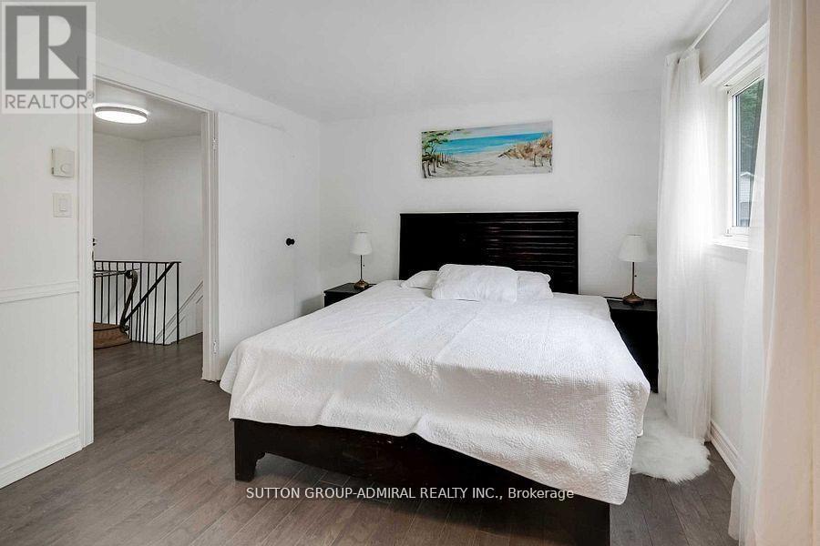 A bedroom with a large bed and a painting on the wall.