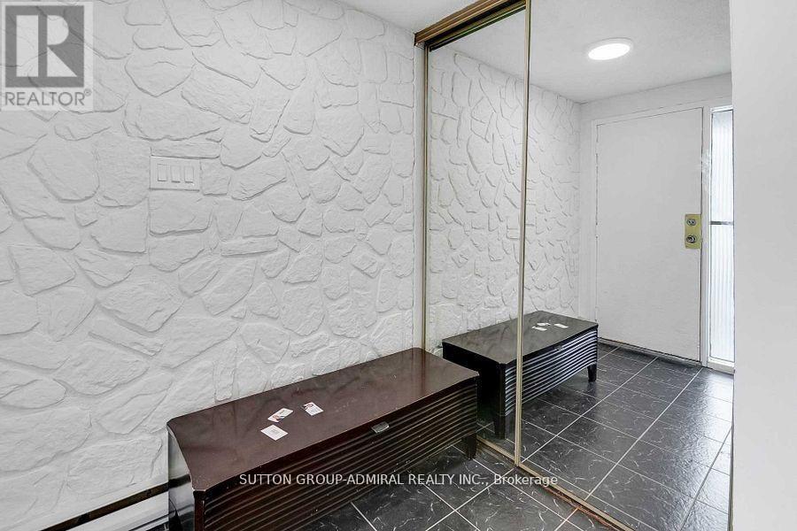 A room with a stone wall and a wooden bench.