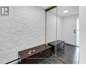 A room with a stone wall and a wooden bench.