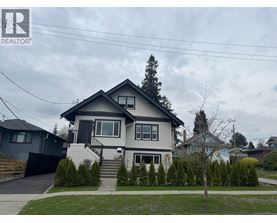 A house with a grey roof and a black fence is for sale.