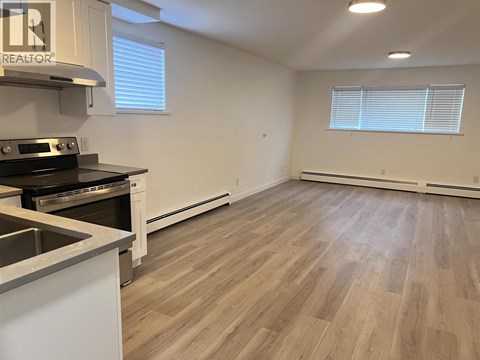 A kitchen with a stove top oven and a sink.