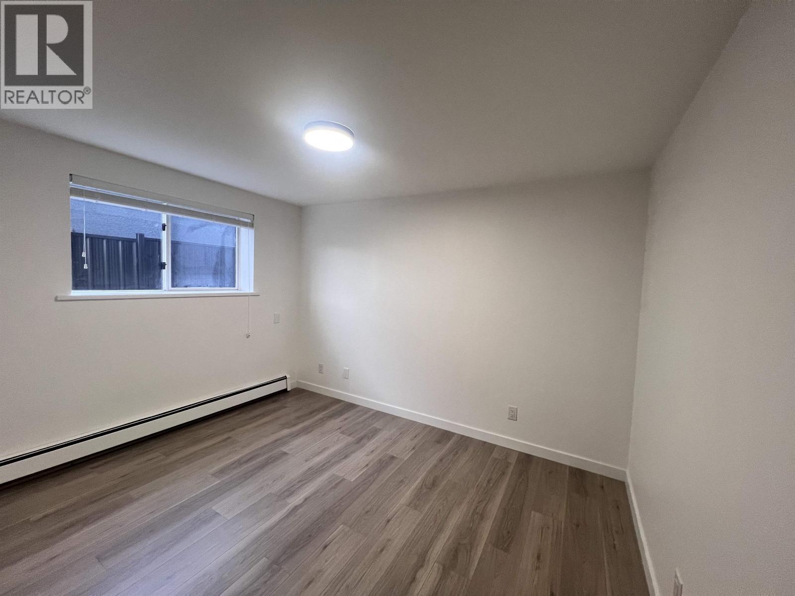 A room with wooden flooring and a window.
