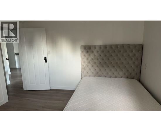 A room with wooden flooring and a window.