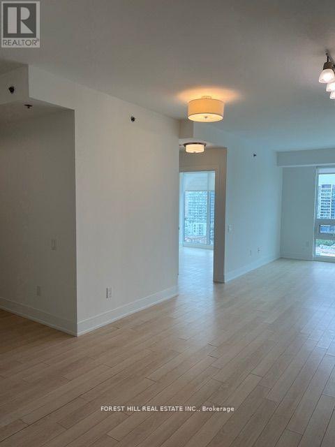 A spacious room with wooden flooring and white walls.