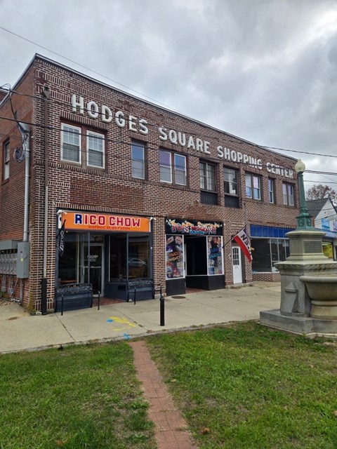 A brick building with a sign that says Hodges Square Shopping Center.
