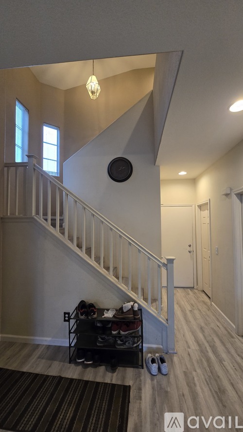 A living room with a couch, a coffee table, and a staircase.