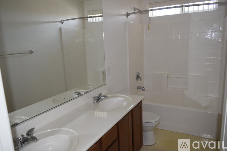 A bathroom with a white sink and a white toilet.