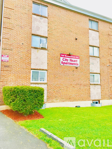 A brick building with a sign that says "City Heart Apartments".