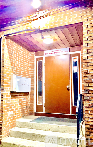 A brown door with a glass window and a sign above it.
